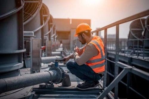 A water resources engineer examines piping at a plant.